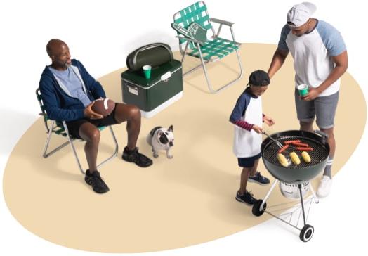 从上面看，一对父子在烤热狗和玉米棒，邻居和他的狗坐在附近的草坪椅上监督他们.